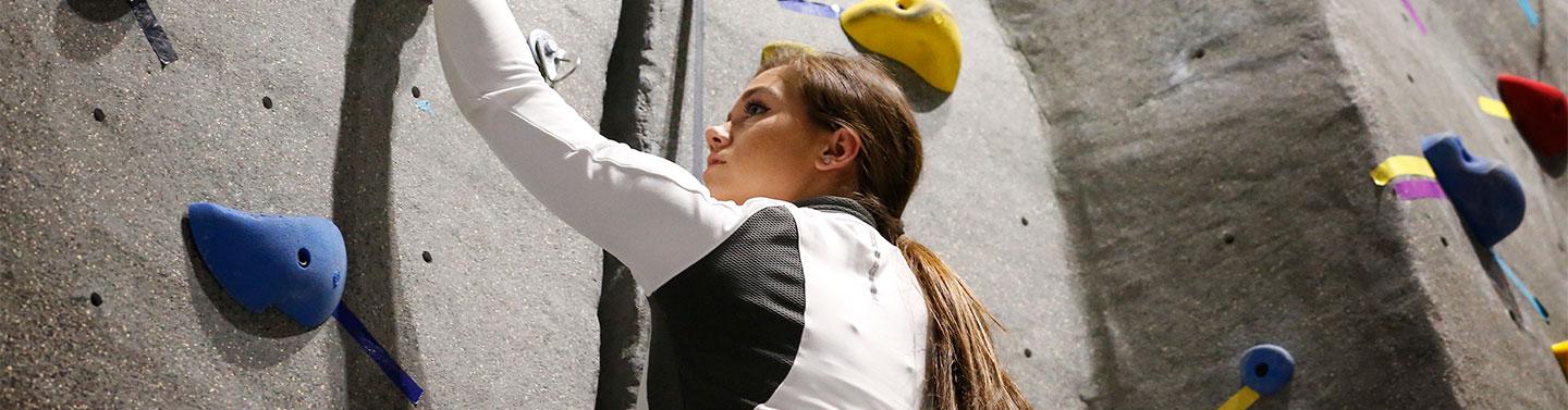 Student climbing rock wall